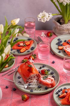 Delicious red velvet crepe cake decorated with fresh strawberries and blueberries, creating a vibrant and tempting dessert for any special occasion