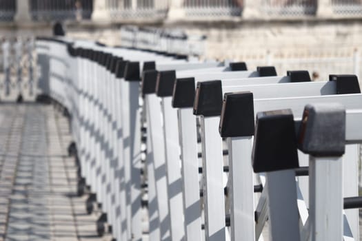 White and black railings line a beautiful walkway on a sunny day.