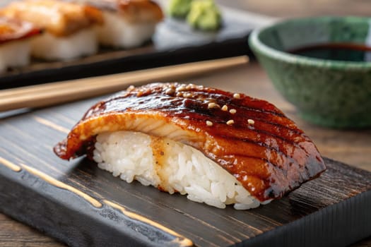 Grilled fish sushi sits on a wooden platter alongside wasabi and soy sauce. This traditional dish showcases artistry in Japanese cuisine, highlighting flavors and textures.