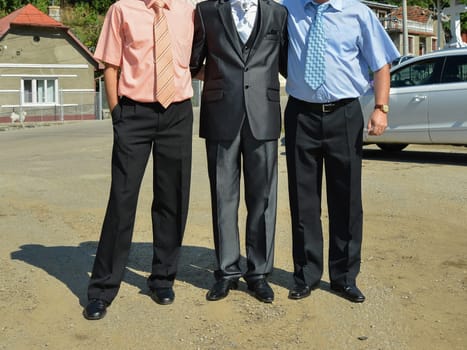 A group of people stand side by side, each wearing distinct formalwear, sharing in the spirit of the occasion