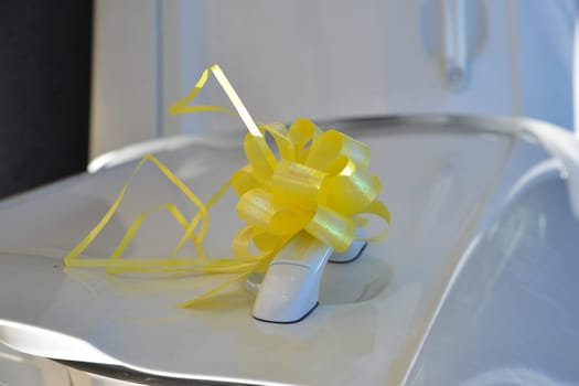 A bright yellow bow adorns a car door handle, bringing a cheerful accent to the festivities