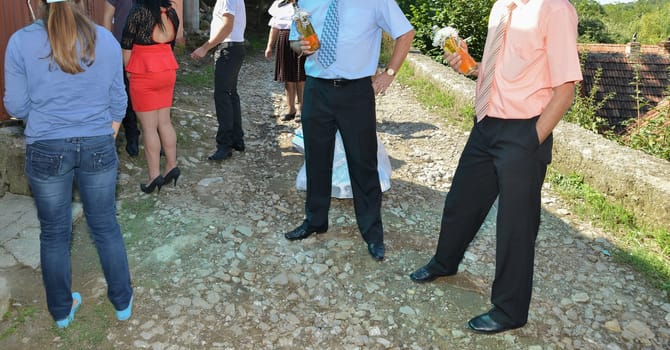 A group of people stand side by side, each wearing distinct formalwear, sharing in the spirit of the occasion