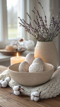 A serene indoor arrangement showcases speckled eggs nestled in a neutral bowl, accompanied by a lit candle and dried lavender, creating a cozy spring atmosphere.