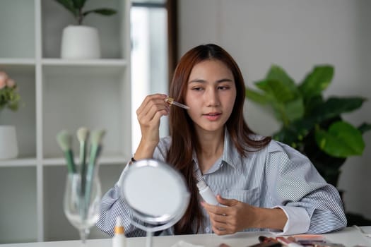 A skincare aficionado applies serum with precision, embracing the essence of beauty and health in her daily routine.