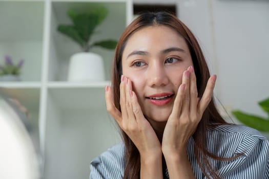 A skincare lover indulges in her routine, applying a product while appreciating her glowing complexion in a serene environment.
