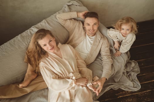 A cheerful family enjoys quality time together on a soft couch, creating joyful memories in a bright and inviting space filled with warmth and love in the afternoon sunlight.