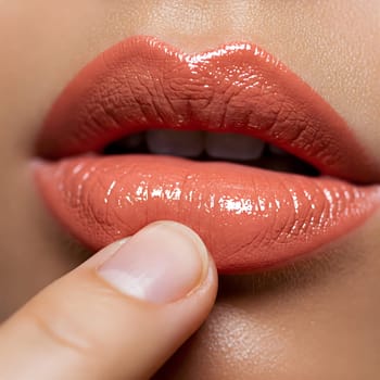Glossy, peach-colored lips with a shiny finish are gently touched by a finger, showcasing the smooth texture of the lipstick. Generative AI