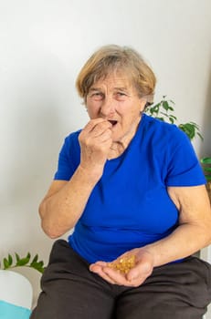 Elderly woman drinks omega 3. Selective focus. people.