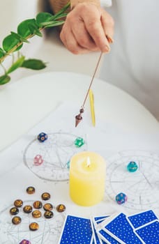 Pendulum fortune telling and astrology. Selective focus. people.