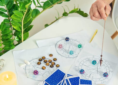 Pendulum fortune telling and astrology. Selective focus. people.