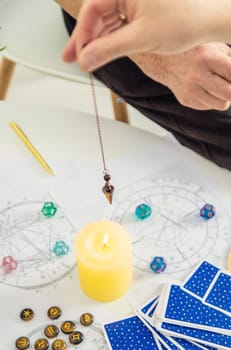 Pendulum fortune telling and astrology. Selective focus. people.