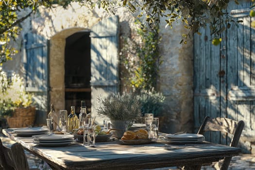 A beautifully arranged outdoor dining table features plates, glasses, and delicious bread in a serene garden. The rustic stone backdrop and soft sunlight create a tranquil atmosphere.
