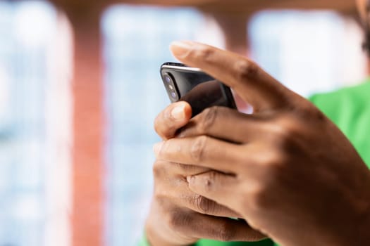 Man in apartment using smartphone to catch up with emails and reply back. Person in home living room reading messages in inbox, typing on mobile phone touchscreen, close up shot
