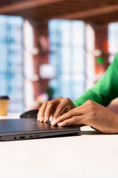 Remote employee at home office desk closing laptop after finishing compose social media posts for the day. Close up of social media manager ending job shift, preparing to leave apartment workspace