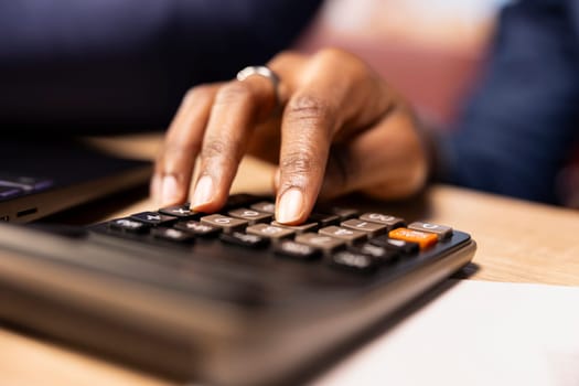 Black people working together on their taxes management at their home office, calculating deductions and ensuring financial stability for the coming year. Couple review savings. Close up.