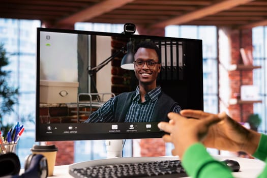 Man at home engaging in a video call with smiling psychologist using PC, listening to advice. Close up of patient in teleconference meeting with friendly therapist providing help
