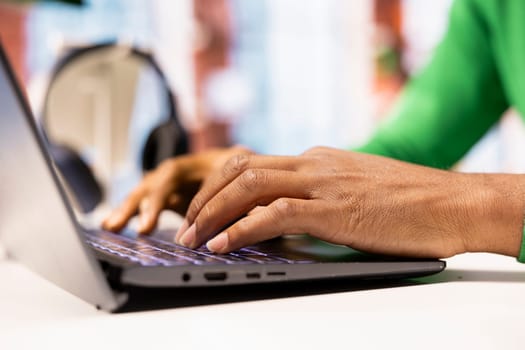 Freelancer at home office desk typing on laptop keyboard to compose social media posts, producing content. Close up of remote worker using notebook to monitor company social media engagement