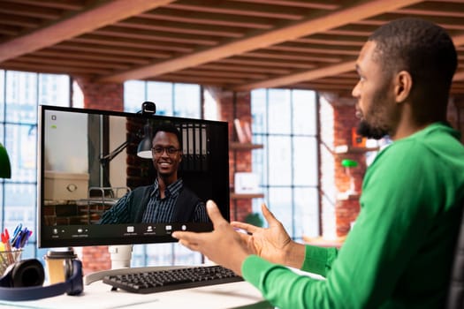 Remote worker calls manager remotely using internet videocall to ask for feedback on project progress. Teleworker at home requesting assistance from team leader in teleconference meeting