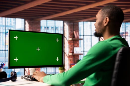 Man using isolated screen PC in home office to write emails. African american person typing on mockup computer keyboard, composing documents in order to deliver finalized project paperwork