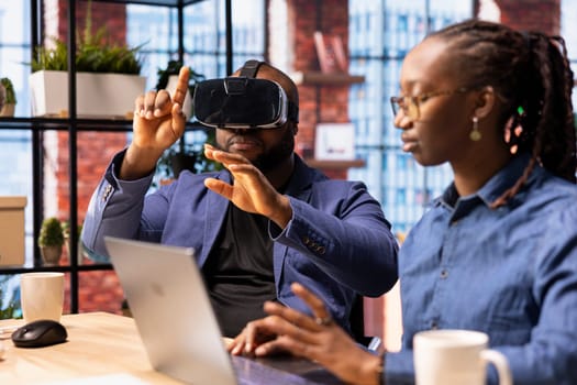 Self employed couple navigates remote work with advanced technology, young man explores 3D simulations through a VR headset. AI, metaverse and innovation in modern freelance careers.