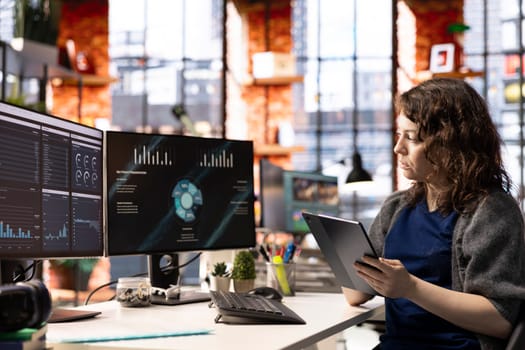 Woman at agency office using financial application UI on PC screen showing company revenue and expenses. Female expert working from apartment doing annual profits review using computer.