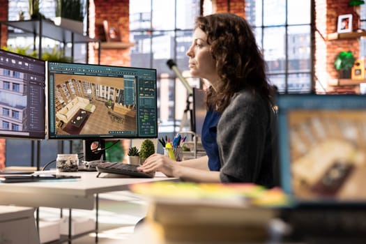Professional architectural designer configures a floor plan on dual monitors, utilizing computer aided design tools. Woman uses software for digital rendering and interior decoration remodeling.
