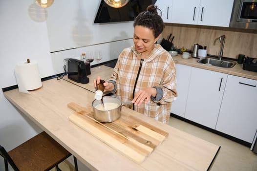 A cheerful woman preparing food in a modern kitchen, showcasing her cooking skills.