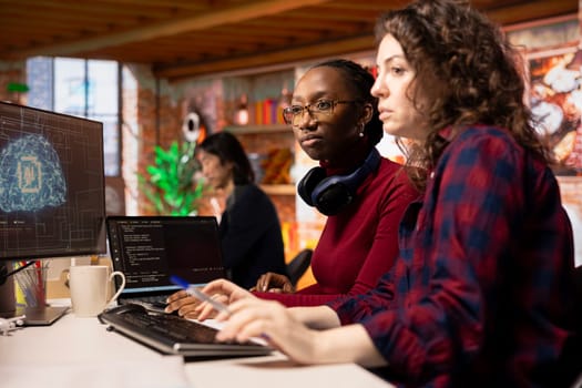 Team of programmers in artificial intelligence focused startup overseeing worker designing, coding and debugging applications. Teamworking colleagues doing code testing and quality assurance
