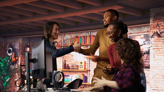 Cheerful startup team cheering after seeing live market updates showing stocks raising, doing high five. Joyous venture staff members overjoyed after becoming publicly traded company, camera B
