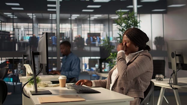 Black CEO feeling tired and working under pressure at the office, search ways to increase funds and achieve goals within multinational company. Stressed overwhelmed businesswoman. Camera B.