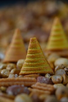 Vibrant conical snacks rise among a colorful display of assorted nuts and seeds, creating an eye-catching centerpiece for a lively gathering full of flavors and joy.