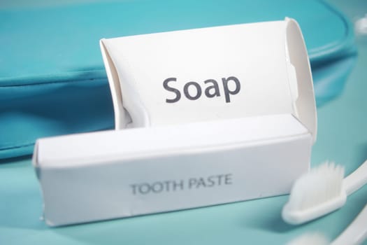 The packaging for soap and toothpaste rests on a vibrant surface.