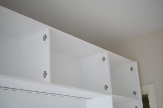 White shelving units with open compartments are installed on a wall.