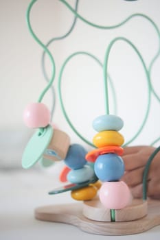 Children engage with a vibrant bead maze for hands-on play and learning.