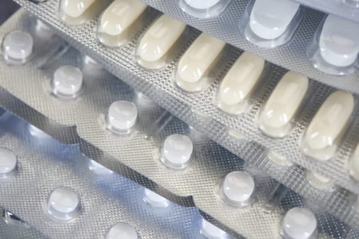 Multiple blister packs of tablets are neatly arranged on a surface.