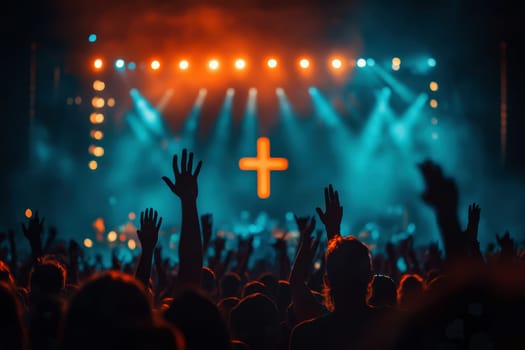 A large group of people raising hands in praise with a cross and illuminated light in the background..
