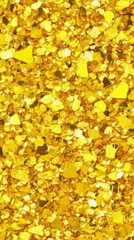 Shiny gold glitter texture forms a vibrant golden background, perfect for adding a touch of luxury and festive sparkle to designs