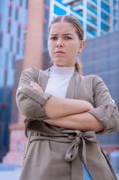 A serious young businesswoman with her arms crossed looking at the camera. She looks confident and approachable, making her an ideal image for business, leadership, success, and empowerment concepts.