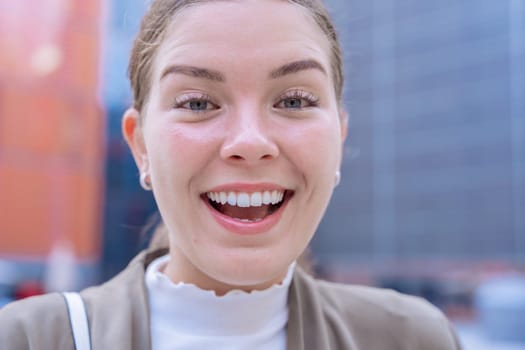 Young Caucasian businesswoman looks at the camera with a radiant smile.She radiates confidence,happiness, and positivity, making her an ideal image for lifestyle, fashion, and personal branding topics