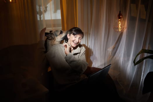 In a warm and inviting apartment, a middle-aged woman shares a relaxing evening with her dog, finding joy and comfort in each other's company.