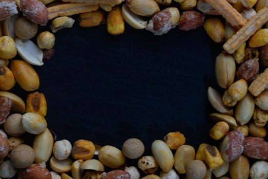A delightful mix of various nuts and snack elements surrounds a dark center, creating an inviting and rich visual texture perfect for culinary presentations.