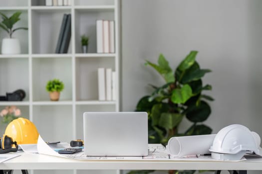 A well-arranged workspace emphasizing productivity in construction, showcasing essential tools, digital devices, and plant decor to create a vibrant environment.