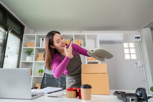 An online seller excitedly prepares a product by inspecting it before placing it in a box for shipping, showcasing the care put into fulfilling each order.
