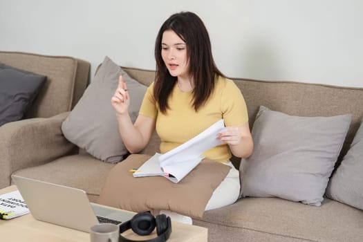 Capturing a moment of a dynamic remote work session, the woman presents her insights over a video call, signifying the blend of technology and professional communication.