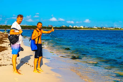 Male tourists men best friends guys are posing for a photo selfie model and having fun swimming on the mexican Caribbean beach in Playa del Carmen Quintana Roo Mexico.