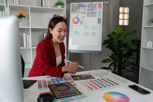 An inspiring designer assesses various color palettes and design samples in a creative workspace filled with artistic materials.