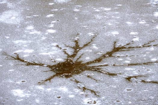 Abstract image of a crack in the ice cover of a muddy lake