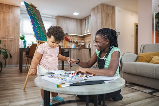 A joyful moment as a caregiver and child engage in artistic activities.