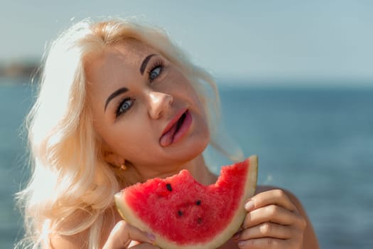Blonde woman with playful expression, tongue out, eating a slice of watermelon near the ocean. Summer vibes.