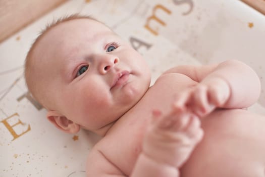 4 months old infant baby boy at changing table, detail on his head